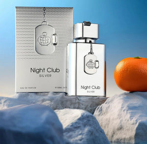 Silver 'Night Club Silver' perfume bottle and packaging with an orange on a textured surface.