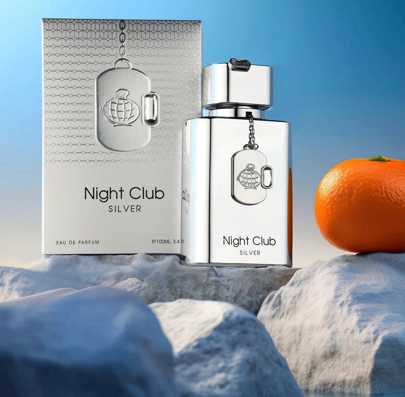 Silver 'Night Club Silver' perfume bottle and packaging with an orange on a textured surface.
